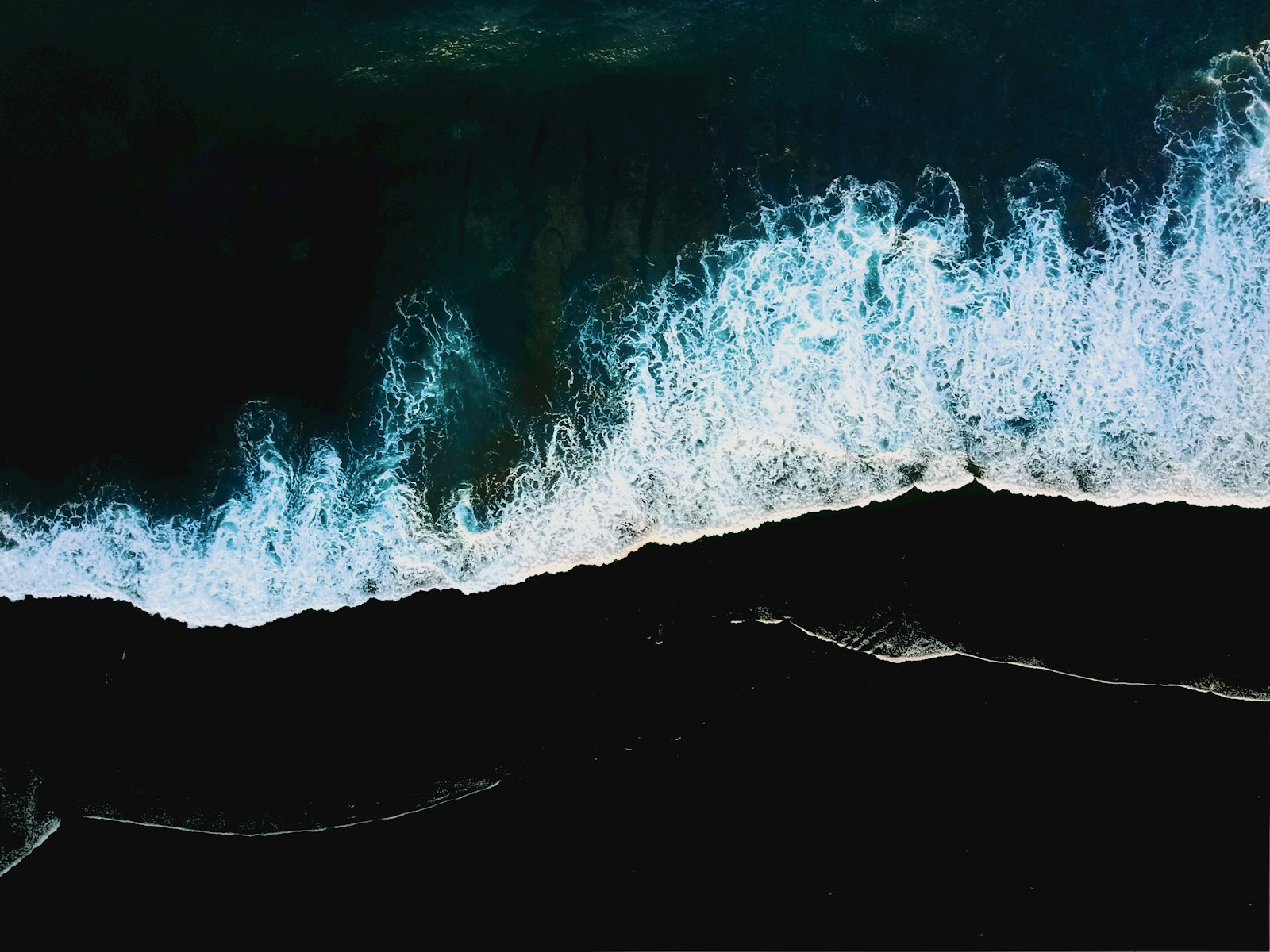 Black-sand coast, Bali — area photograph · Alexey Marchenko / Unsplash